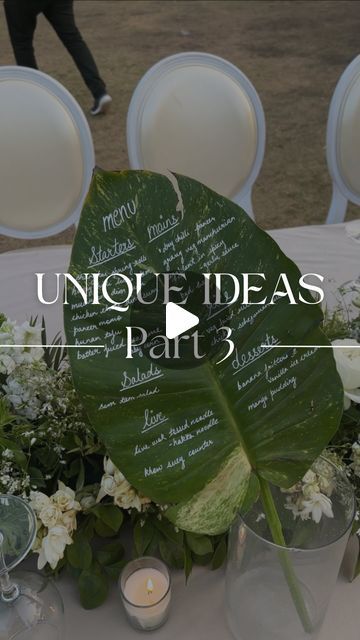 the table is set with white flowers and greenery