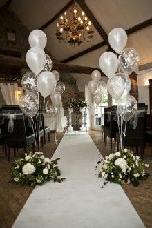 balloons and flowers on the aisle at a wedding