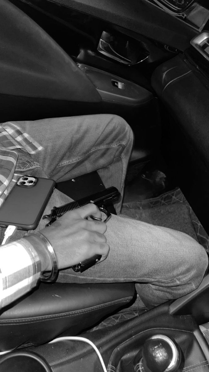 a man sitting in the back seat of a car using a laptop computer