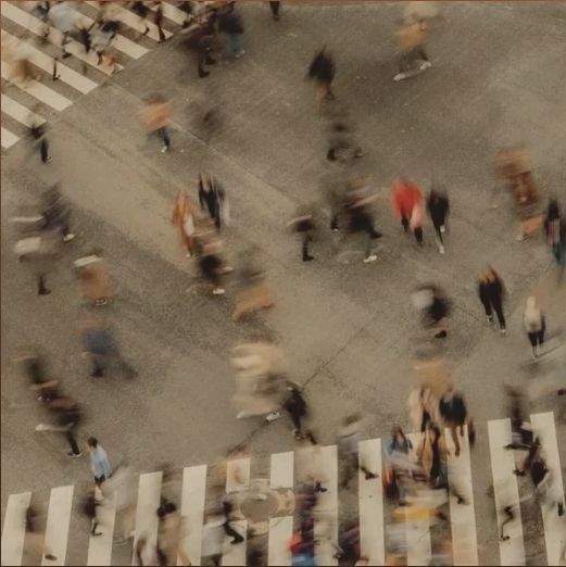 an aerial view of people walking across a crosswalk