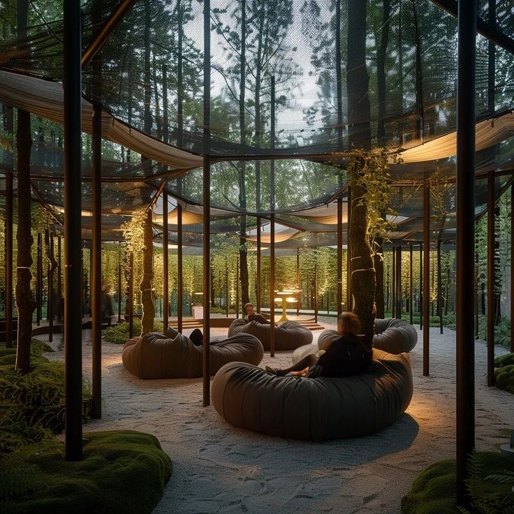 an outdoor lounge area in the middle of a forest with lots of trees and plants