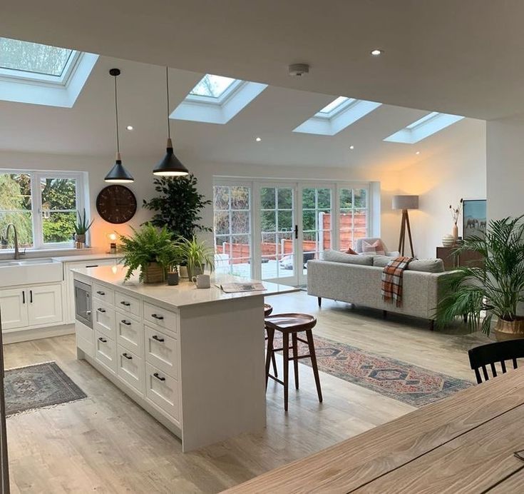 an open kitchen and living room with skylights