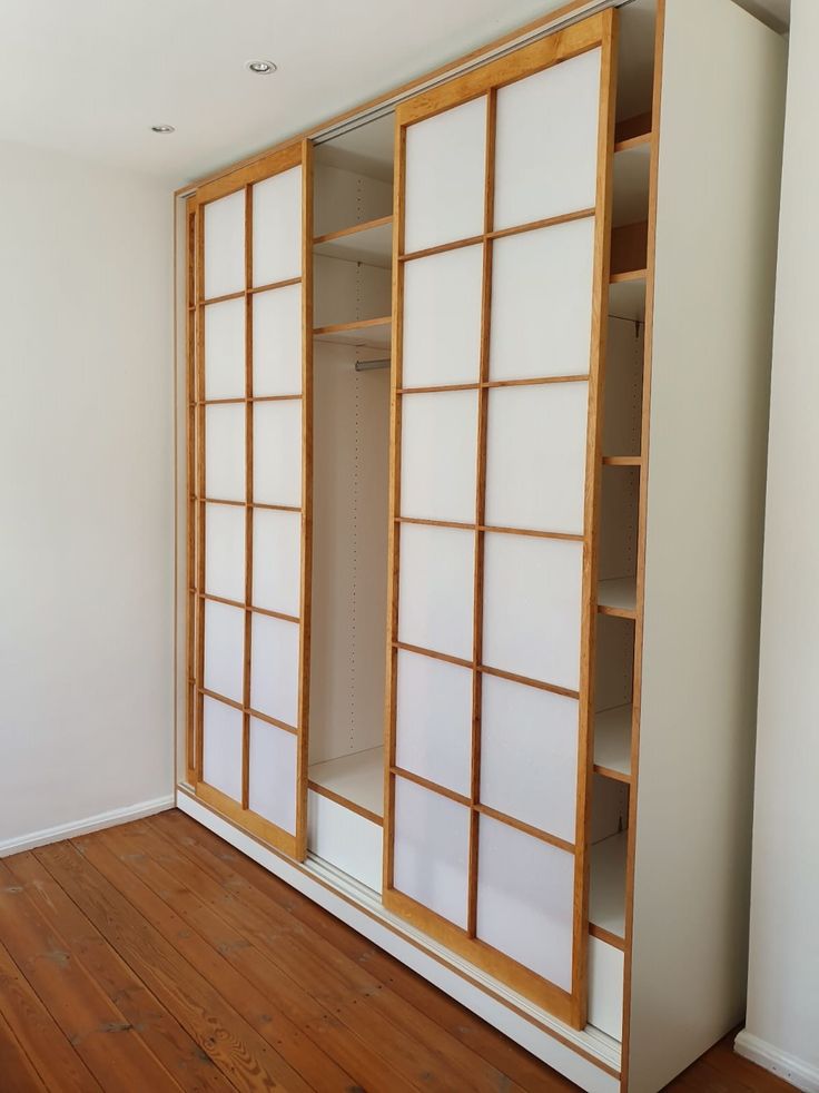 an empty room with sliding doors and wood flooring on the wooden floor in front of it