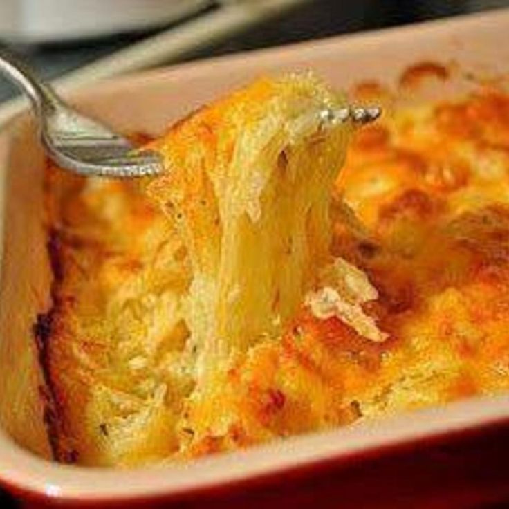 a person holding a fork in a casserole dish