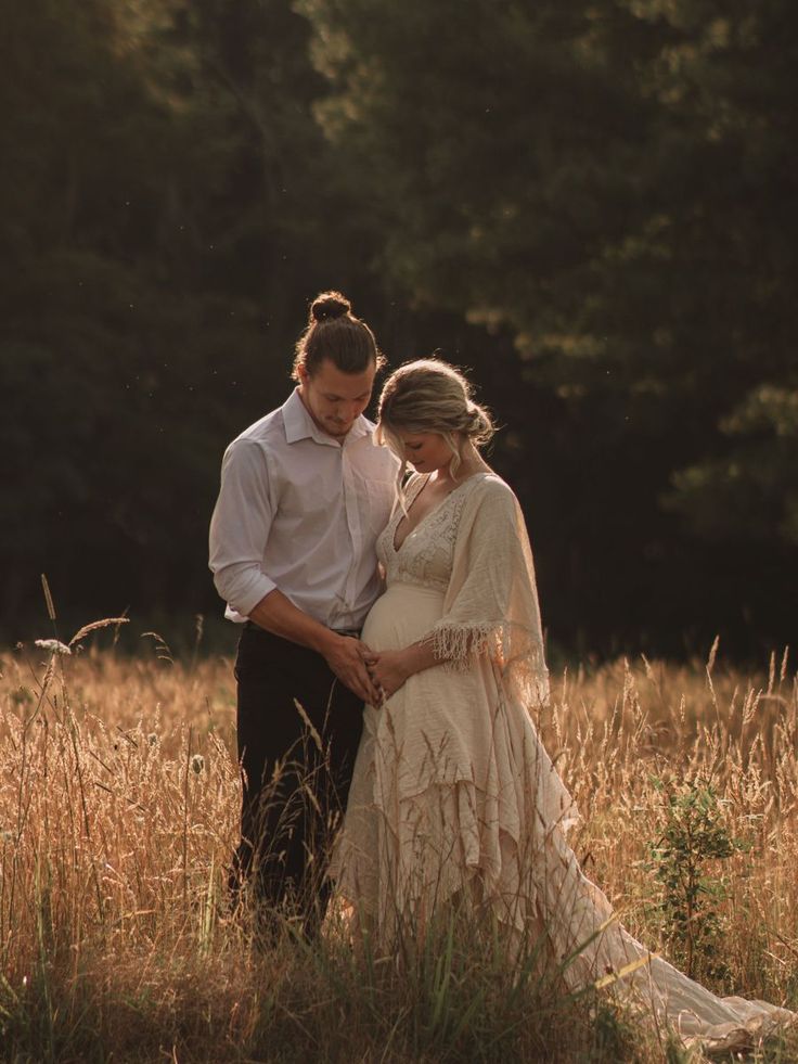 a man and woman standing in tall grass