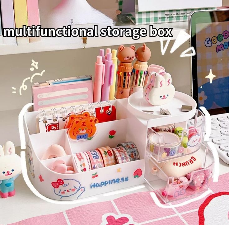 an assortment of stationery items in a toy storage box on a desk next to a computer