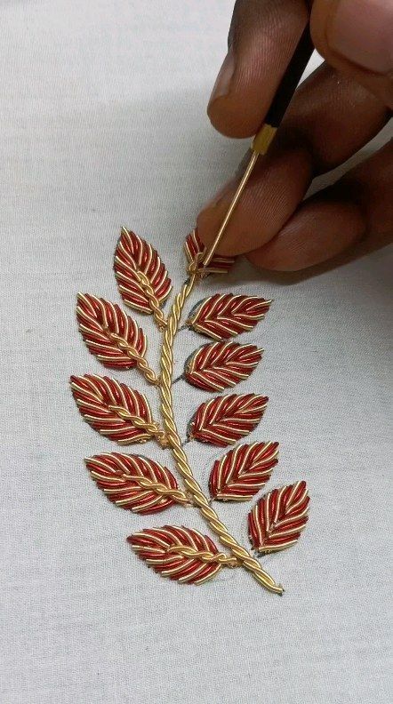 someone is working on an embroidered leaf