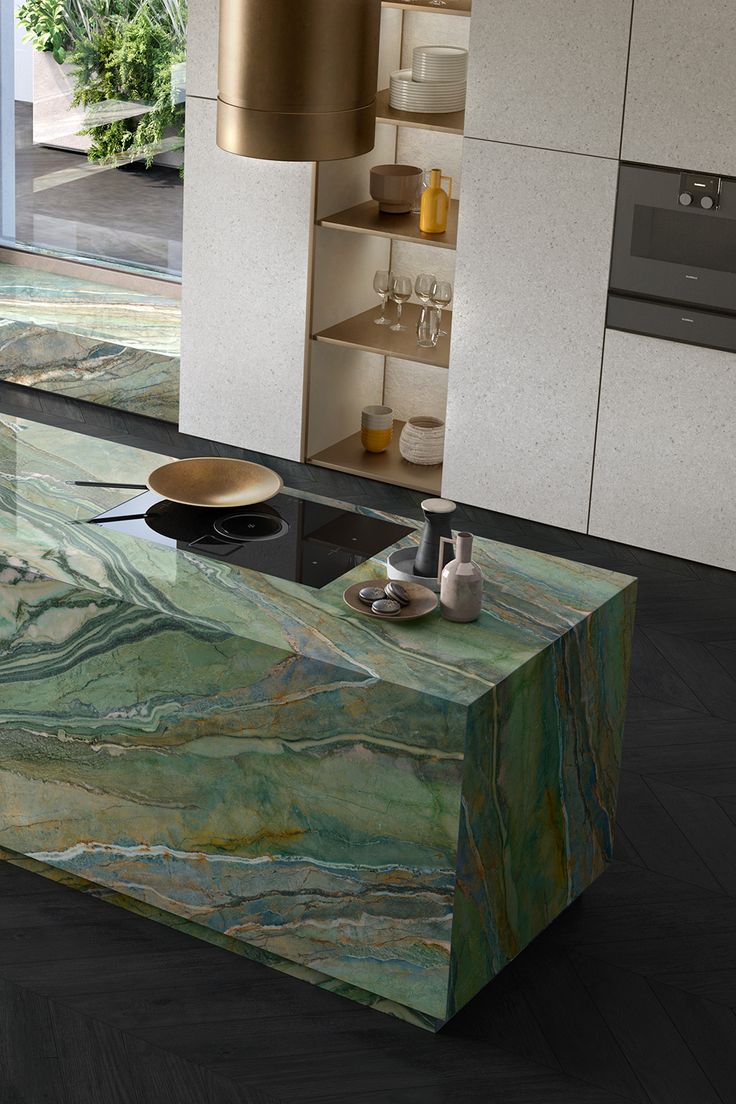 a modern kitchen with green marble counter tops