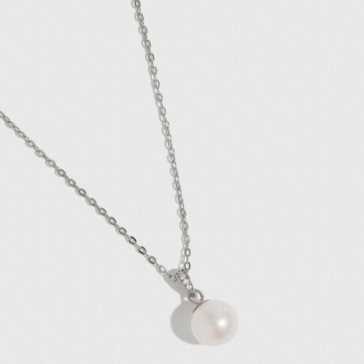 Indulge in elegance with this luminous white freshwater pearl necklace, the perfect match for any occasion. Featuring a timeless gem and a blend of classic and contemporary design, it is thoughtfully curated to highlight your unique style and leave a lasting impression of sophistication. Classic White Gold Pearl Necklace As Gift, Pearl White Timeless Necklace For Anniversary, White Classic Necklace With Delicate Chain, Elegant White Gold Solitaire Necklace With Delicate Chain, Classic Pearl Necklace With Delicate Chain, Elegant Pearl Jewelry With Pearl Pendant, Formal Fine Jewelry Pearl Clavicle Necklace, Silver Jewelry With Pearl Charm In Refined Style, Dainty Silver Pearl Necklace