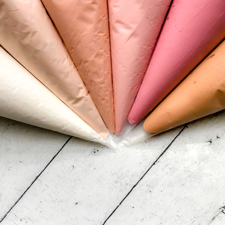 four different colored umbrellas sitting on top of a white wooden floor next to each other