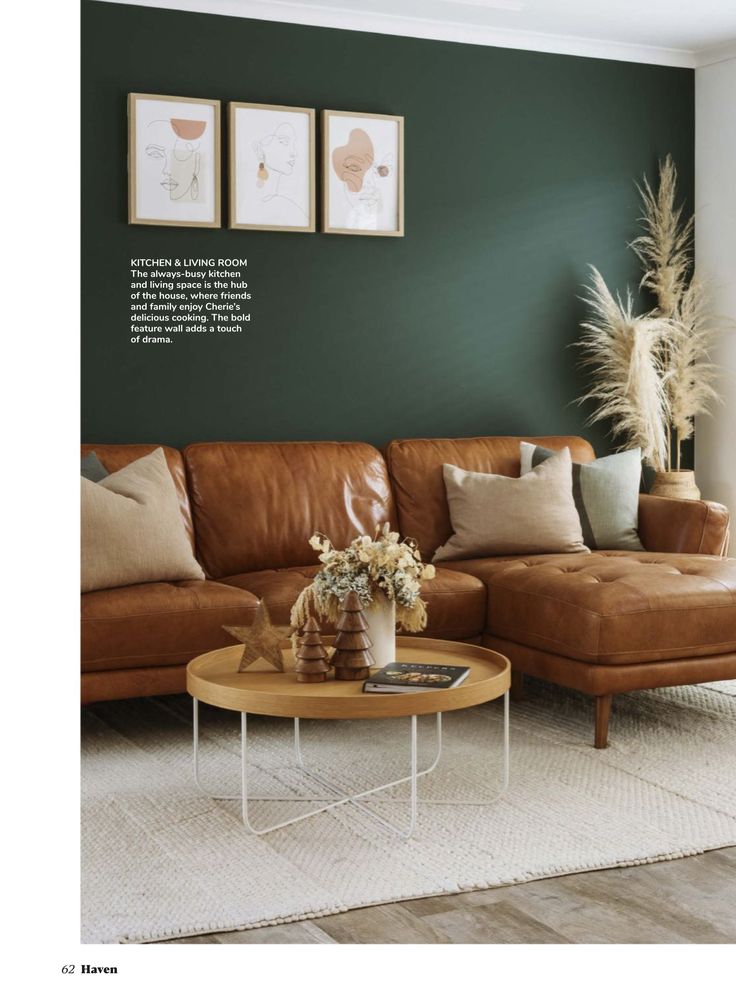 a living room with green walls and brown leather couches, coffee table and rug