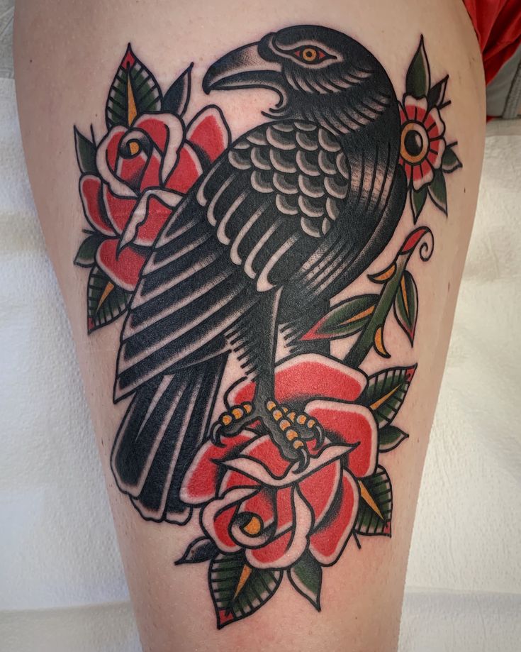 a black bird sitting on top of a red rose flower covered thigh with roses around it