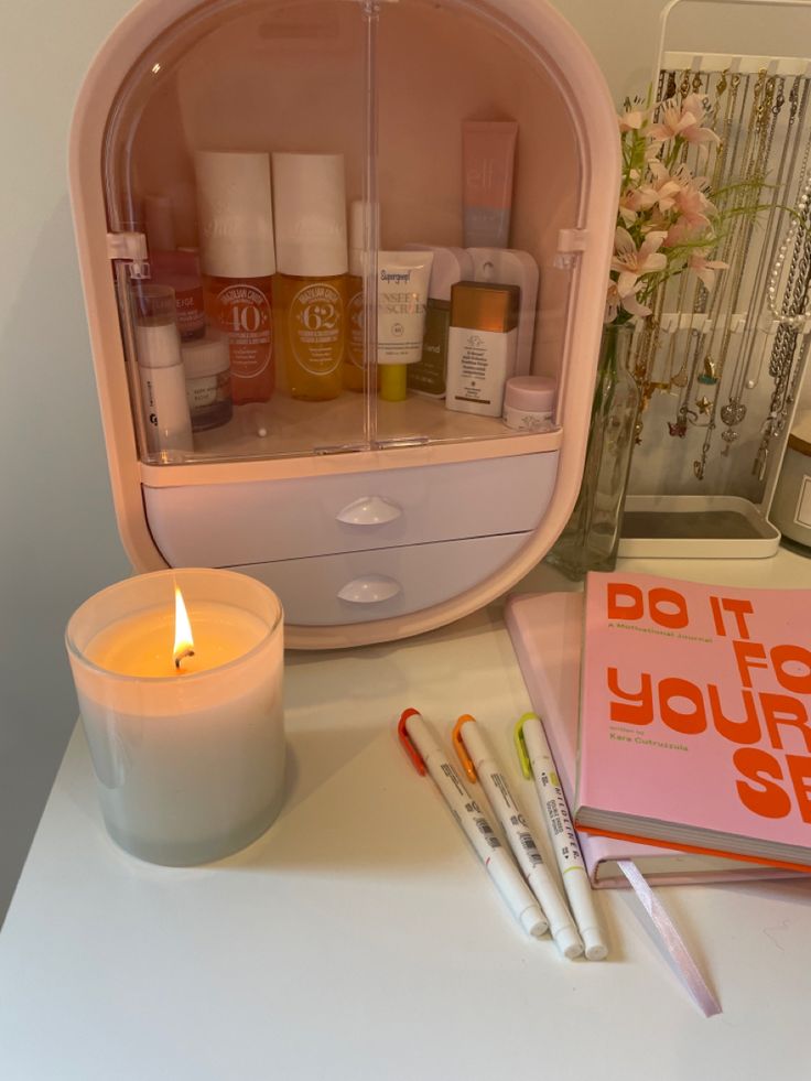 the contents of a personal care kit are arranged on a table next to a candle