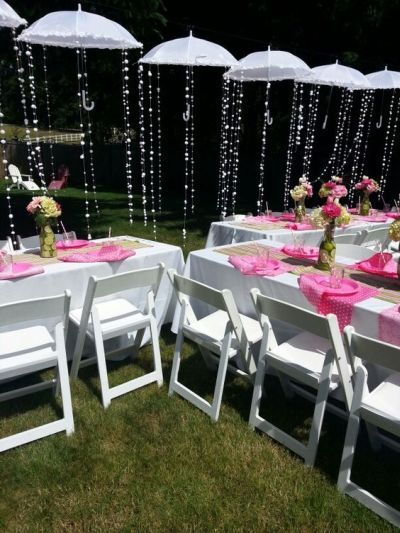 tables set up with white chairs and pink tablecloths