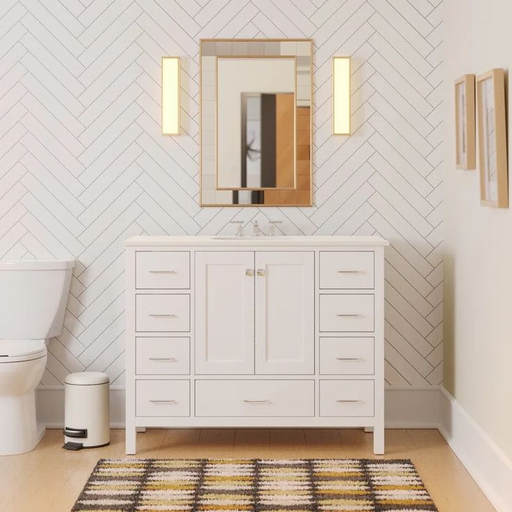 a bathroom with a white vanity, toilet and mirror on the wall next to it