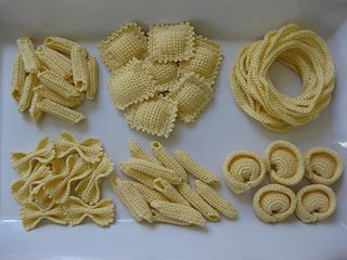 several different types of pasta on a white counter top next to some noodles and other items