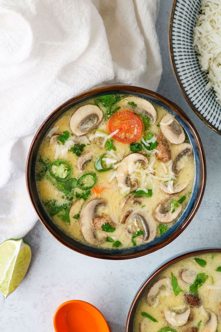 two bowls filled with food next to rice