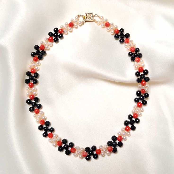 This elegant Coral, Pearl and Jade Necklace is the perfect accessory for any occasion. Delicately crafted with black jade, red coral, and freshwater pearls, this unique piece of jewelry is an eye-catching touch of sophistication to your look today! Black Jade (5mm) Red Coral (5mm) Freshwater Pearls (4mm) Goldfilled clasp Length: 15" Elegant Red Beaded Pearl Necklace, Elegant Red Round Pearl Necklace, Elegant Red Pearl Necklace With Gemstone Beads, Elegant Red Beaded Necklace With Black Beads, Elegant Red And Black Beaded Necklaces, Elegant Red And Black Beaded Necklace, Elegant Pearl Necklace With Colorful Beads For Gift, Black Jade, Jade Necklace