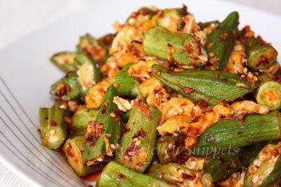 a white bowl filled with green beans covered in sauce