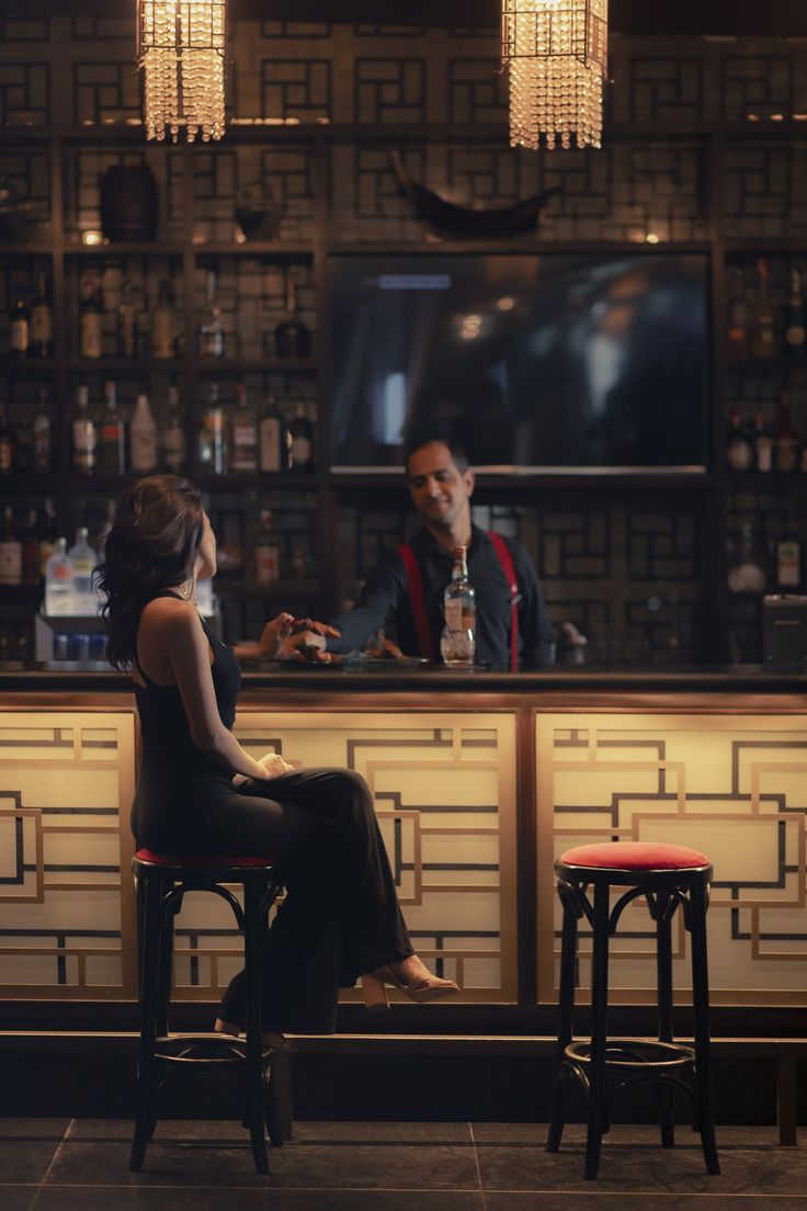 a man and woman sitting at a bar