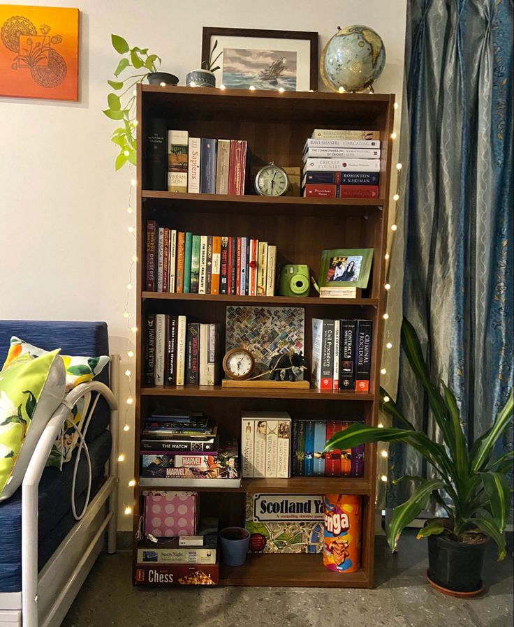 a bookshelf filled with lots of books next to a bed