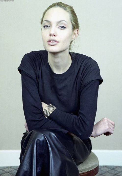 a woman sitting on top of a chair with her arms crossed