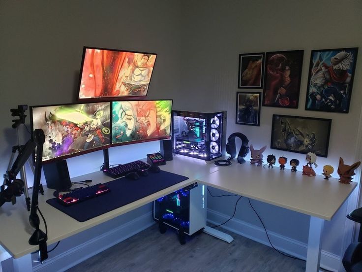 a computer desk topped with three monitors and gaming accessories