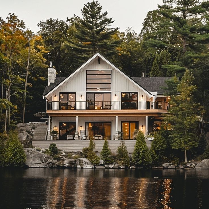 a house sitting on top of a lake surrounded by trees