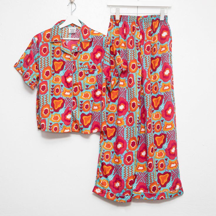 Our pajama sets are like wrapping yourself in a hug from your favorite auntie. With one-of-a-kind prints designed to represent, you'll slide into bed feeling like royalty. The top? Short-sleeved and just loose enough, because we know nobody's got time for feeling stuffy. And these pants – they've got that stretchy waistband, so go ahead and have that extra slice of pie, honey. Plus, pockets! Now, can we talk about this print? It’s a whole mood, showcasing the beauty and grace of Black women. Eve Spring Patterned Sleepwear For Pajama Party, Patterned Sleepwear For Pajama Party In Spring, Multicolor Cotton Lounging Sets, Multicolor Cotton Loungewear Sets, Floral Print Patterned Sleepwear For Loungewear, Multicolor Printed Sleepwear For Pajama Party, Playful Printed Sleepwear With Relaxed Fit, Playful Printed Sleepwear In Relaxed Fit, Playful Printed Relaxed Fit Sleepwear