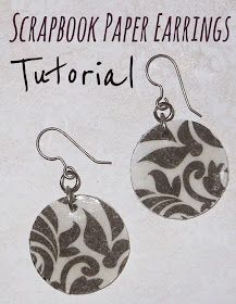 a pair of earrings with black and white swirls on the front, sitting on top of a piece of paper