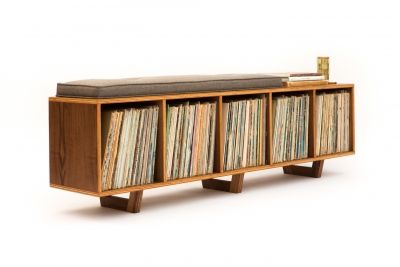 an old record player with many records on it's sides and a bench made out of bookshelves