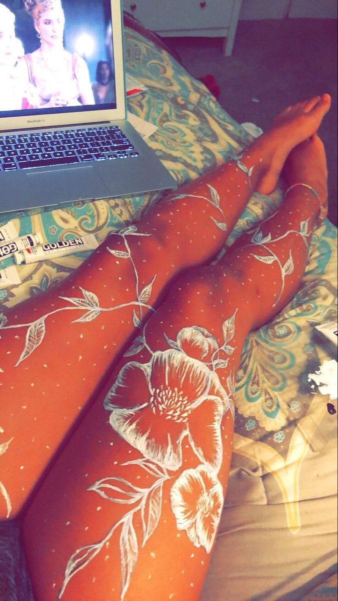 a woman laying on top of a bed with her legs covered in orange and white stockings