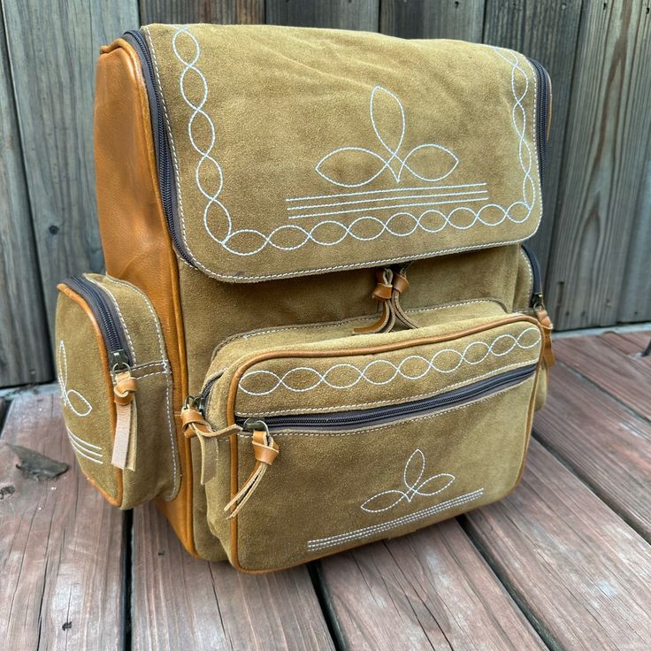 a brown backpack sitting on top of a wooden floor next to a fence and wood planks