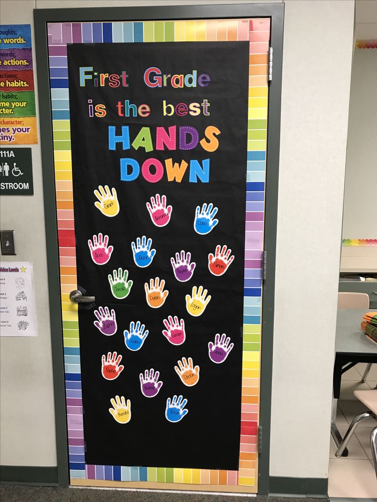 a classroom door decorated with hand prints and the words first grade is the best hands down