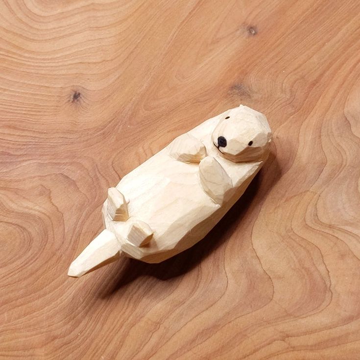 a small wooden animal sitting on top of a wooden floor