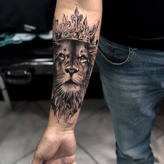 a lion with a crown tattoo on his arm