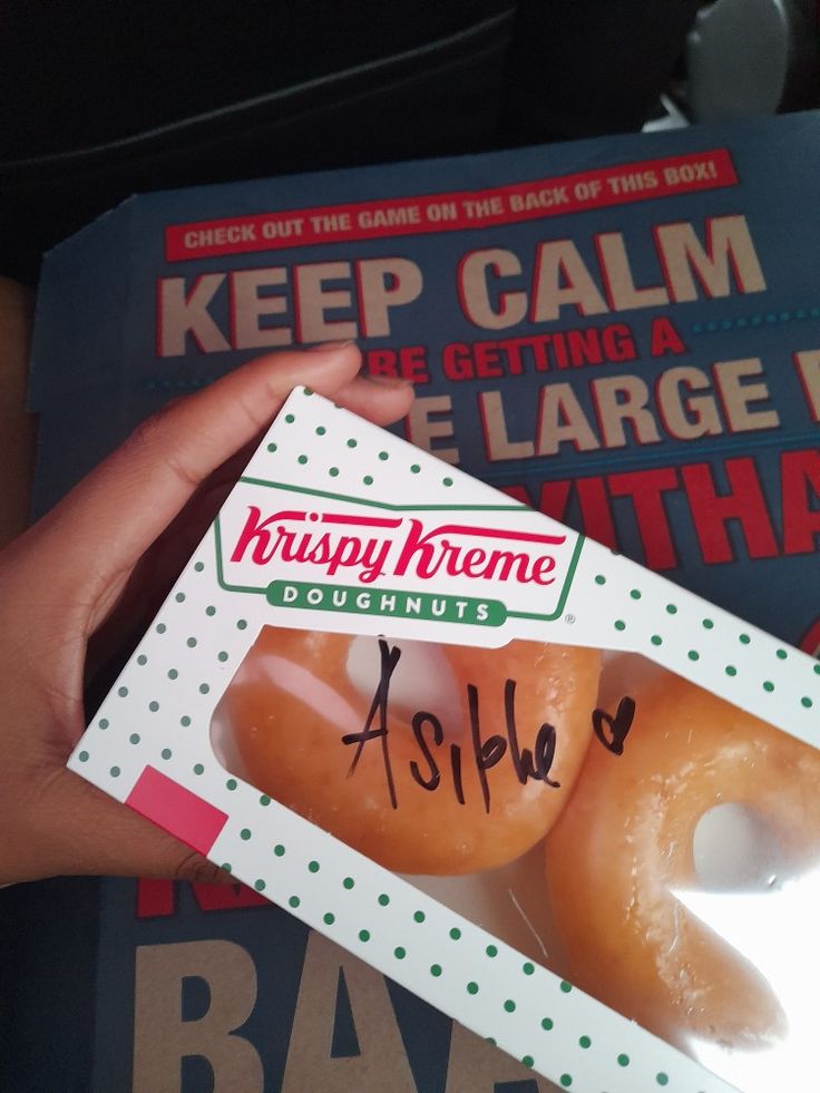 two donuts in a krispy kreme box with writing on the front