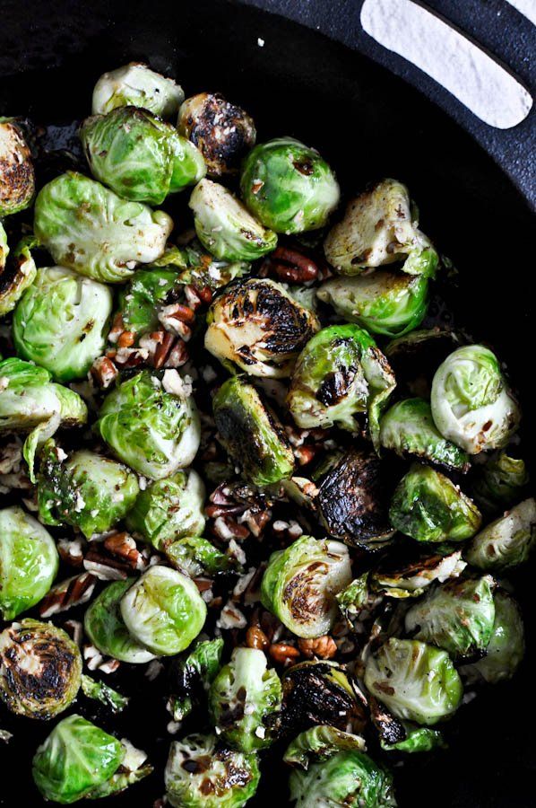 brussel sprouts with pecans in a cast iron skillet ready to be cooked