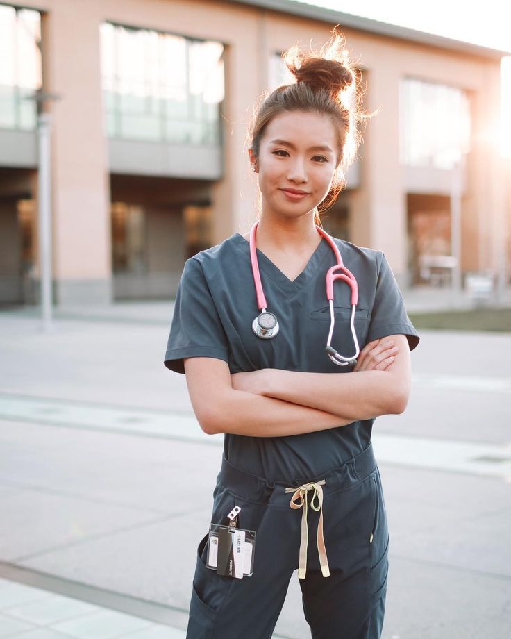 a woman in scrubs is standing with her arms crossed and wearing a stethoscope