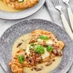 two plates filled with food sitting on top of a white table cloth covered in silverware