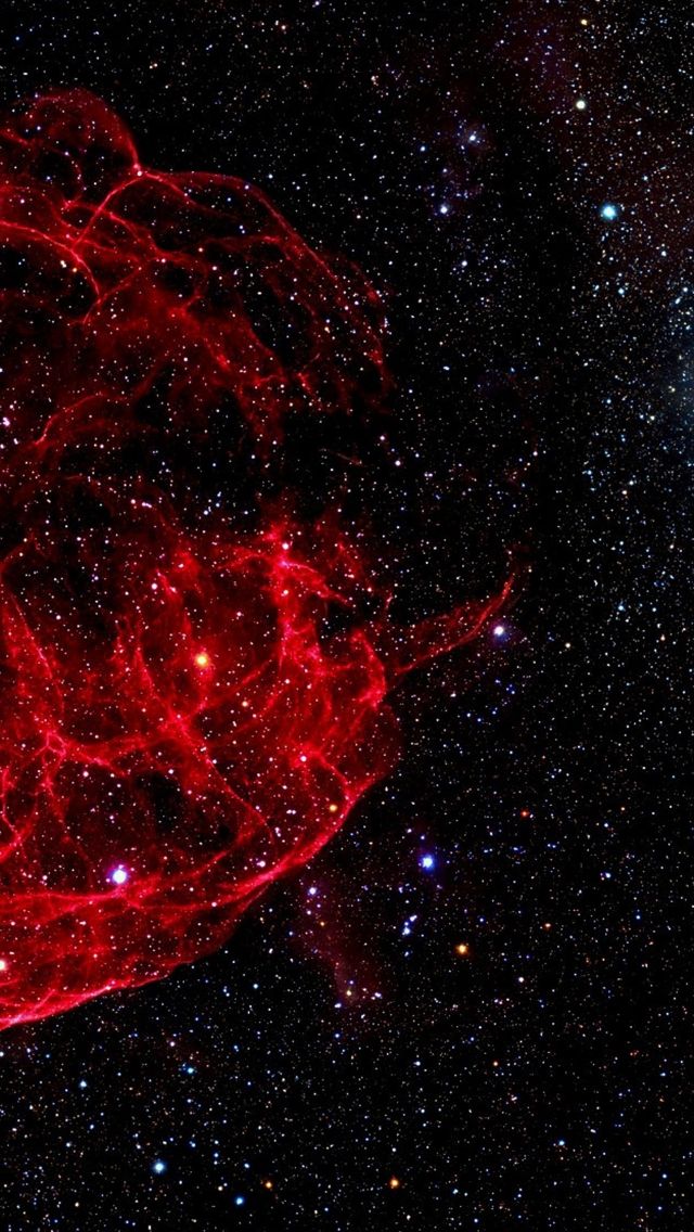 an image of a red object in the middle of space, with stars around it