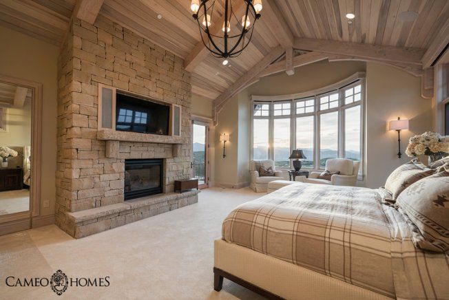 a bedroom with a large bed and fireplace in it