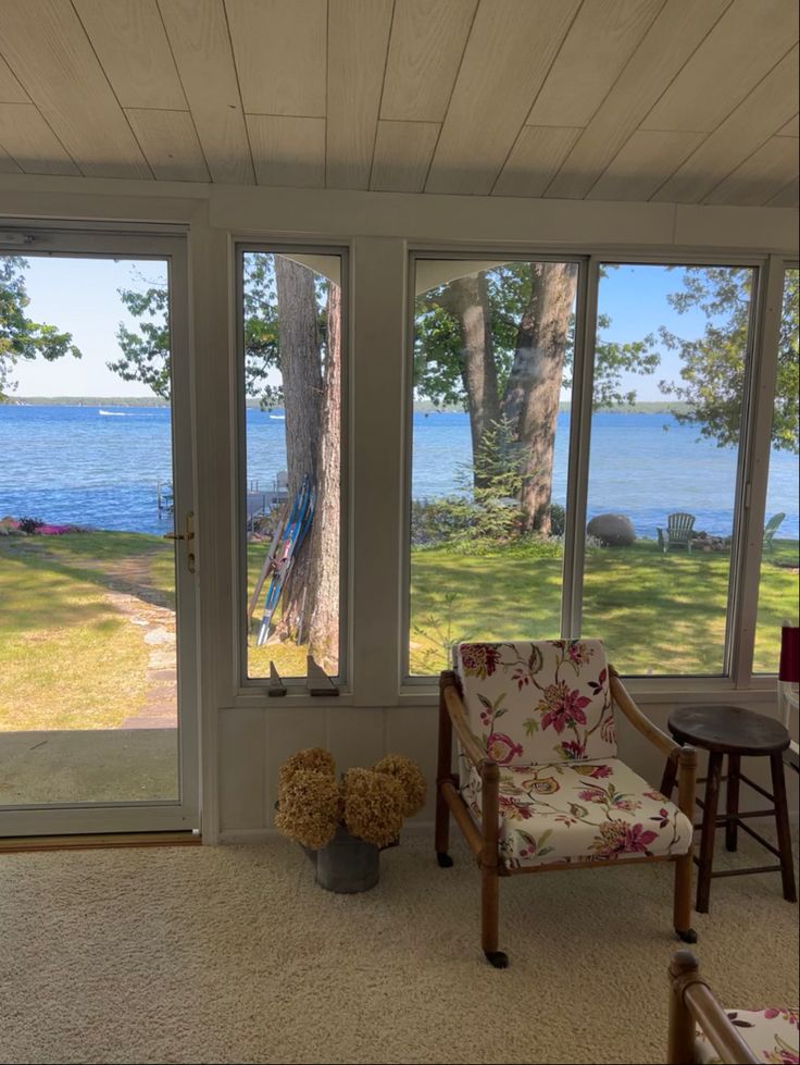 a living room filled with furniture and lots of windows overlooking the water's edge