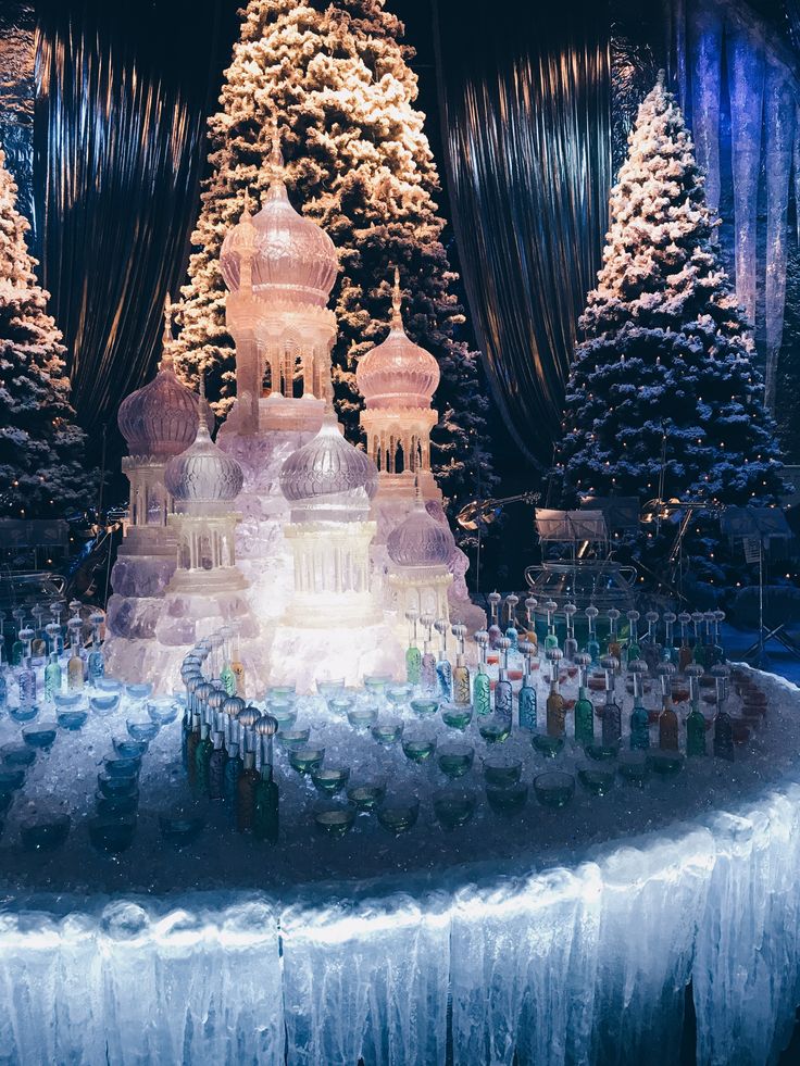 an elaborate display of bottles in front of a christmas tree with snow on the ground