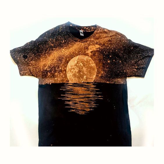 a t - shirt with the image of a full moon reflected in water on it