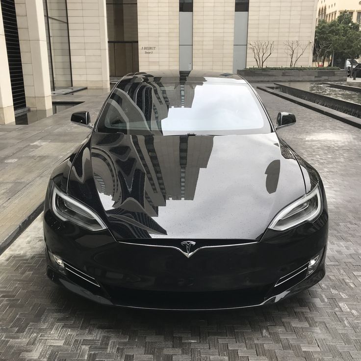 a black car is parked in front of a building