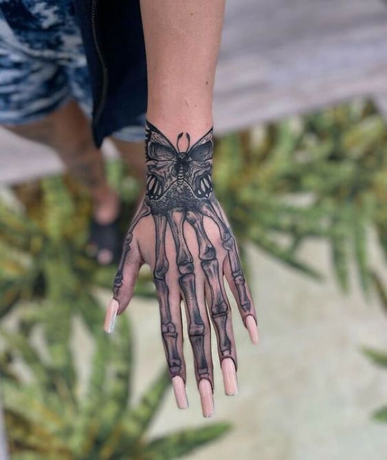 a person's hand with tattoos on it and a butterfly tattooed on the palm