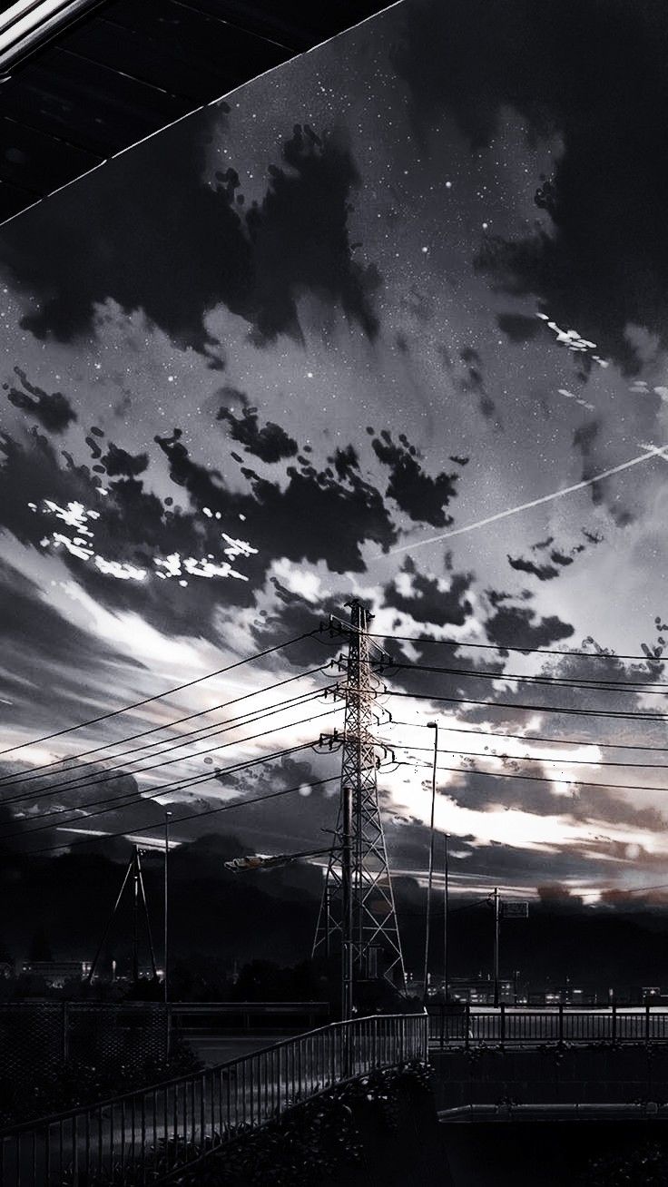 black and white photograph of power lines in the sky with clouds above it at night