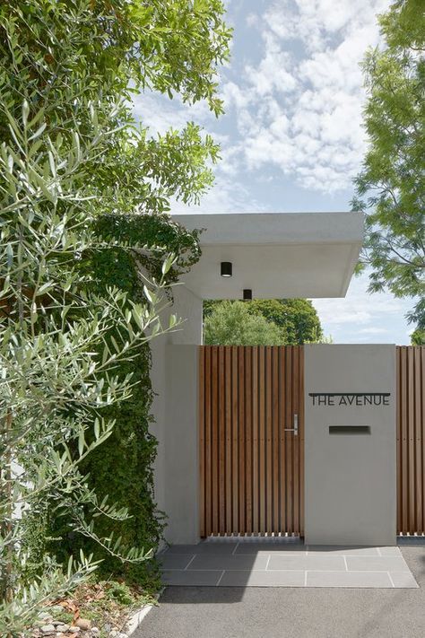 an entrance to a modern home surrounded by trees and bushes with the name the avenue written on it