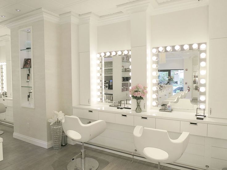 a salon with chairs, mirrors and lights